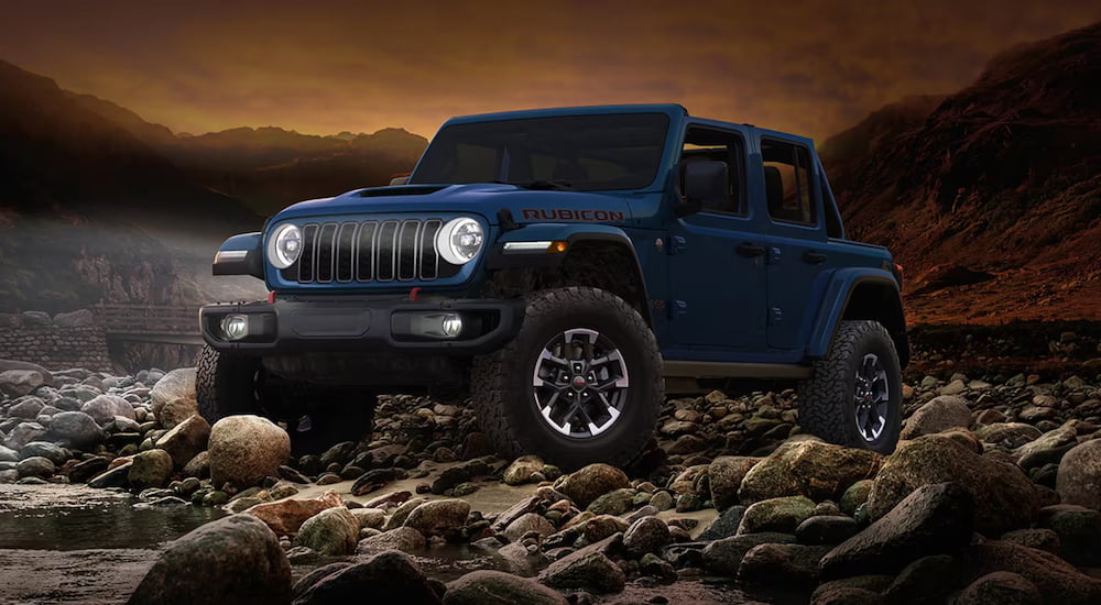 Blue 2026 Jeep Wrangler parked off-road.