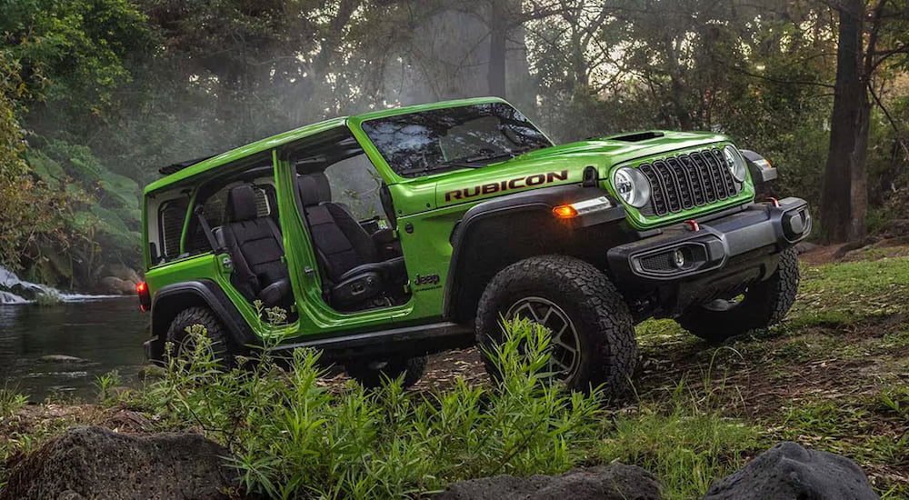 Green 2026 Jeep Wrangler driving through a forest.