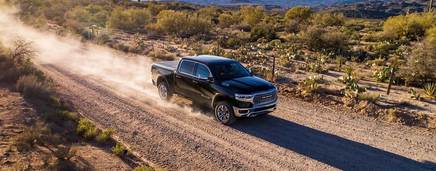 Black 2019 Ram 1500 Limited driving down a dusty trail