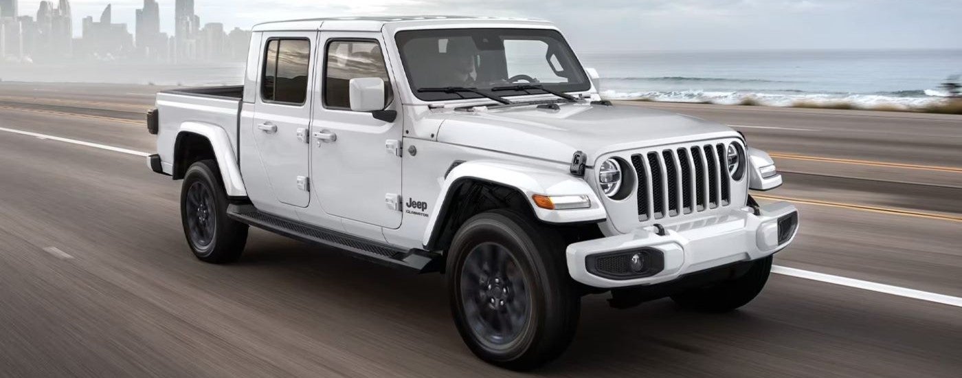 White 2020 Jeep Gladiator driving to a Jeep dealer near Novi