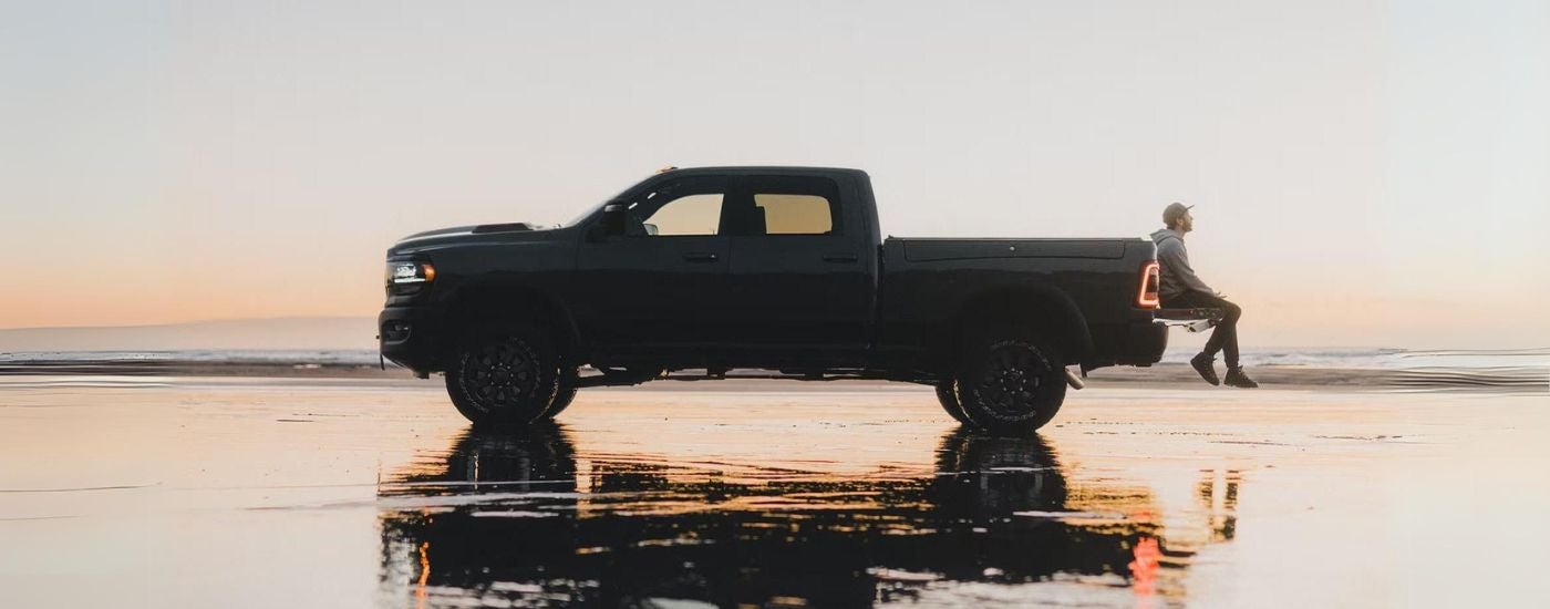 Black 2025 Ram 2500 parked on a beach at dusk