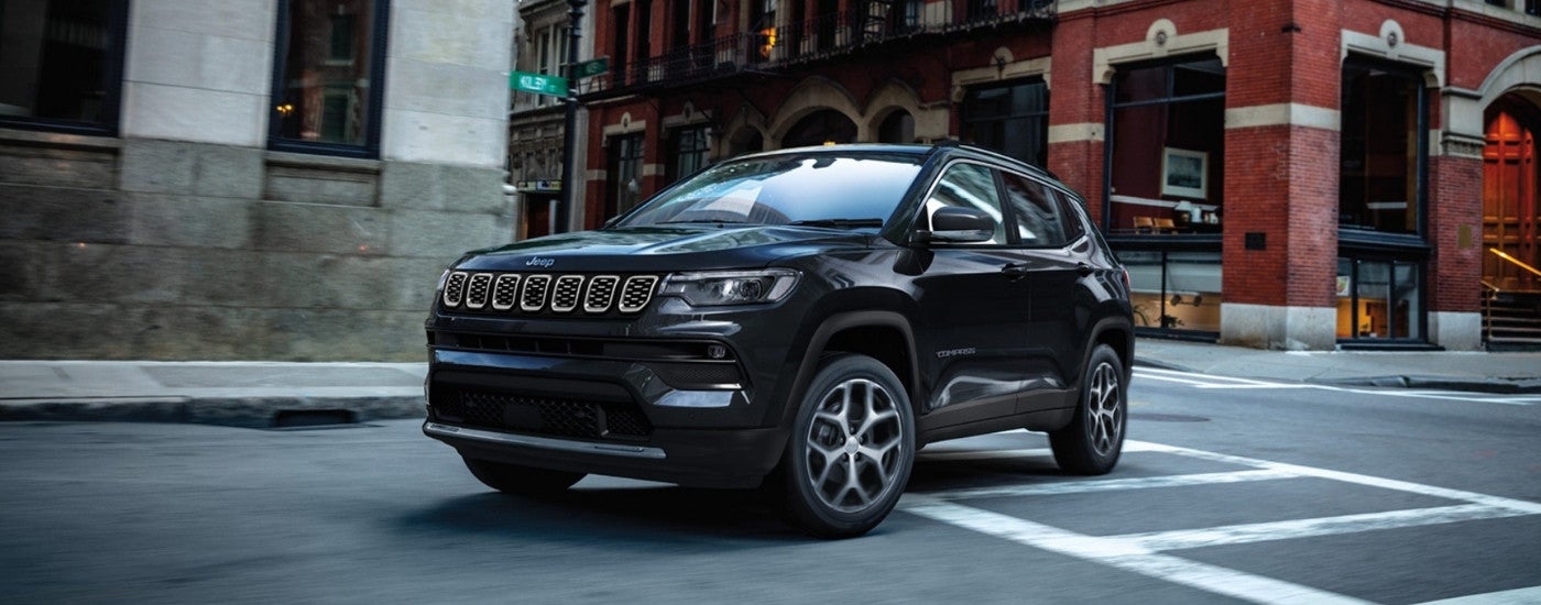 Black 2025 Jeep Compass driving through an intersection