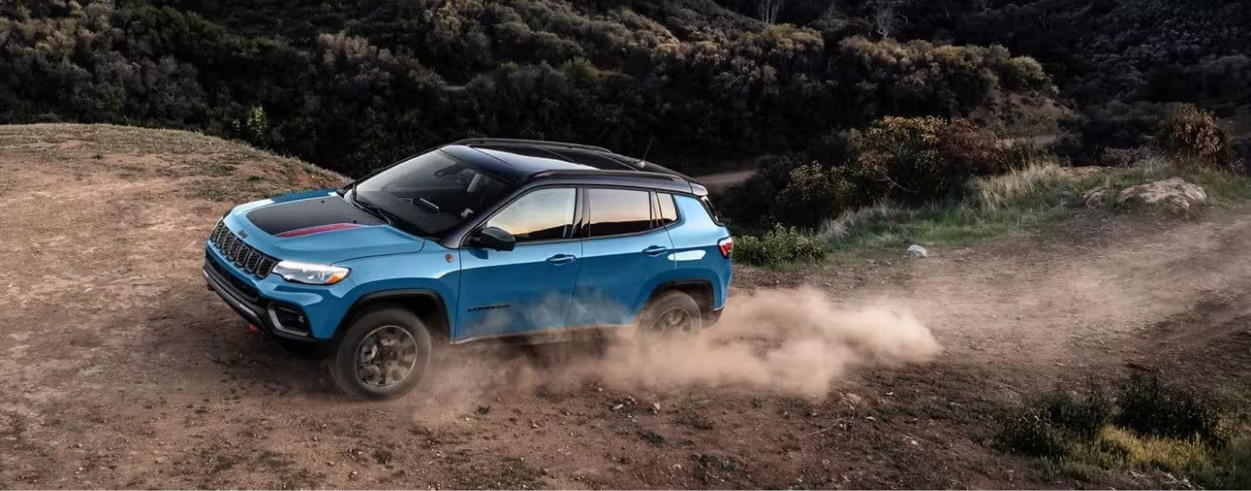 Blue 2025 Jeep Compass driving off-road