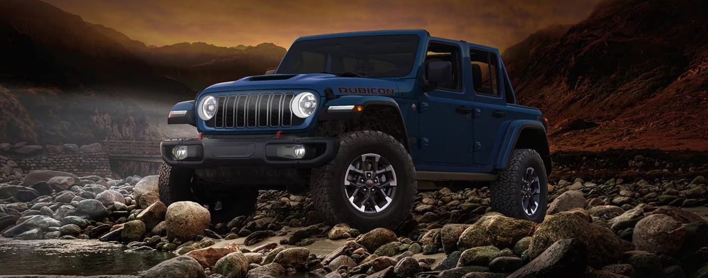 Blue 2026 Jeep Wrangler Rubicon off-road at night.