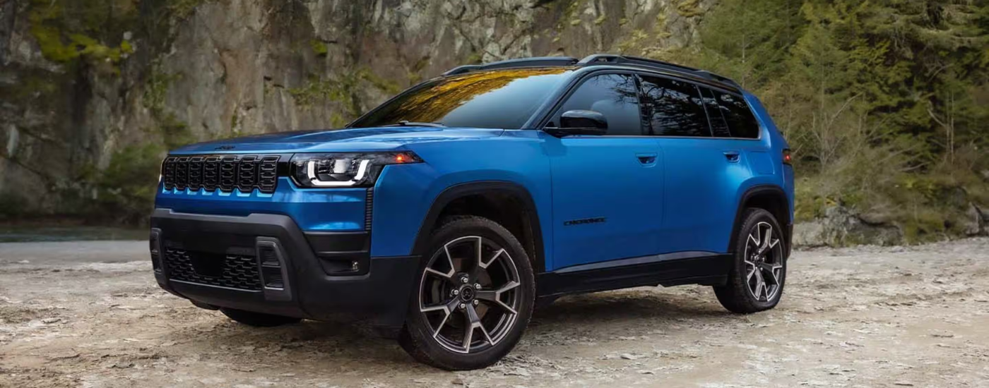 Blue 2026 Jeep Cherokee parked off-road at an angle