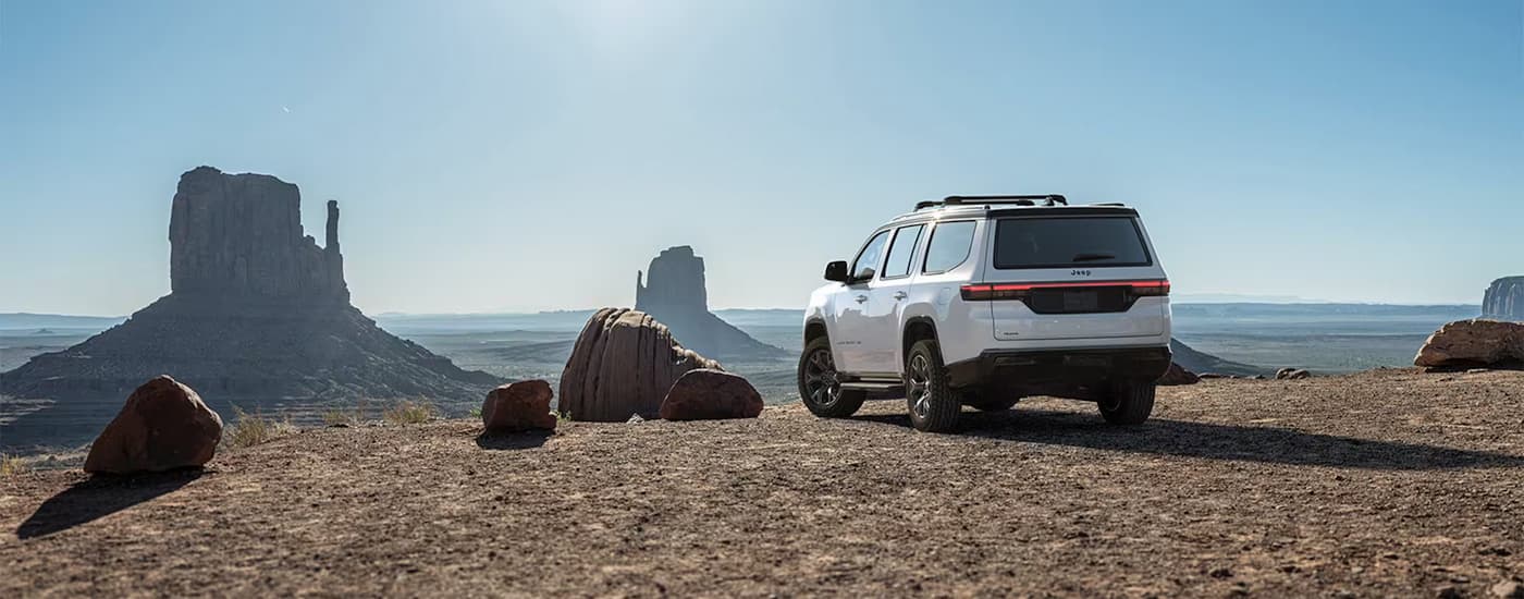 Rear of a white 2026 Jeep Grand Wagoneer parked off-road.