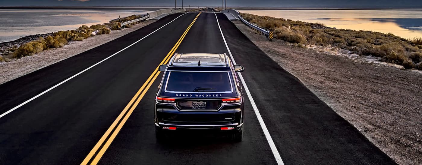 A black 2023 Grand Wagoneer L driving.