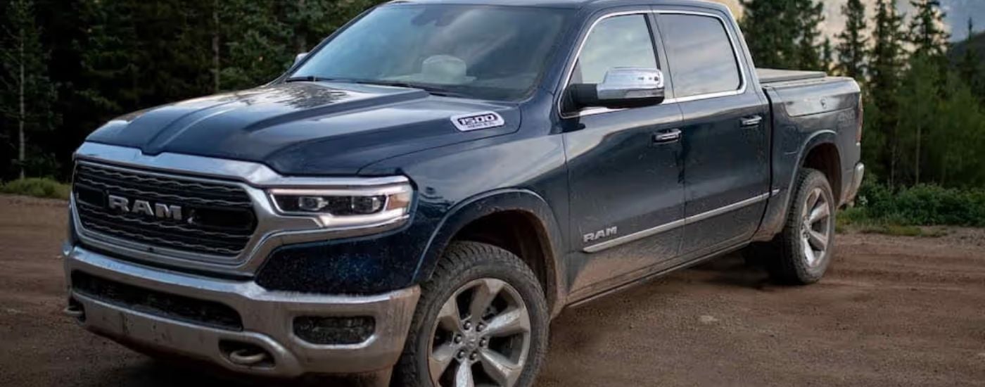 Blue 2022 Ram 1500 Limited parked on a dirt trail.