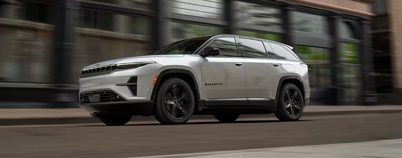 A silver 2025 Jeep Wagoneer S driving to a Jeep dealer.