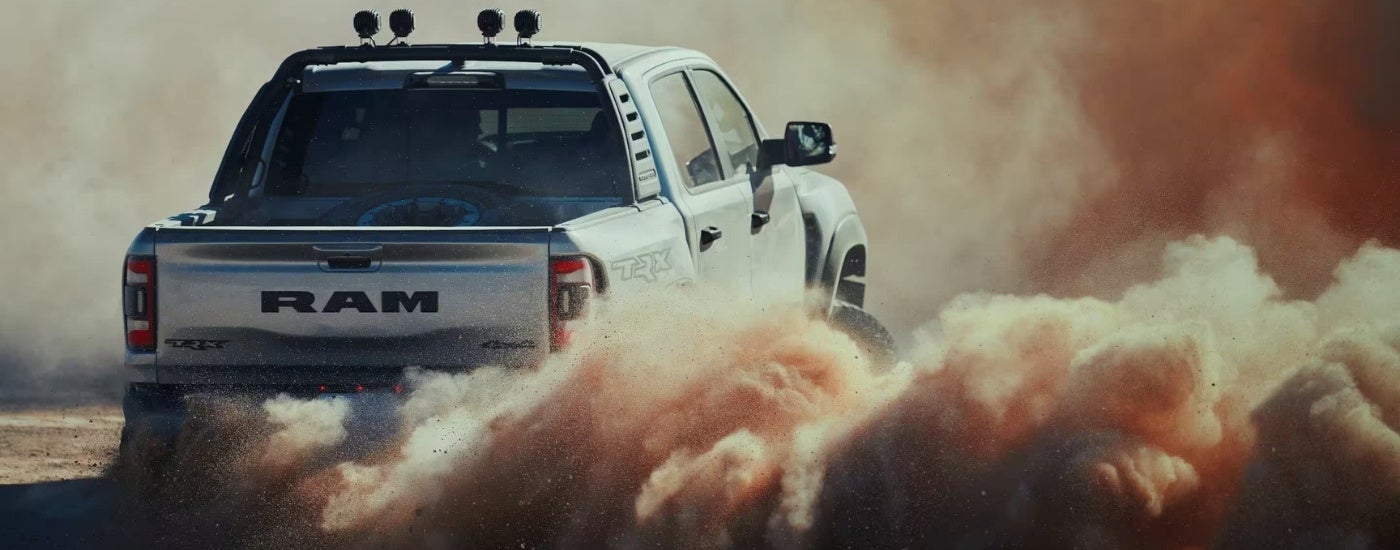 A grey 2023 Ram 1500 TRX driving to a Ram dealer.
