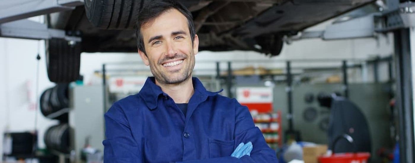 A technician smiling at a tire shop.