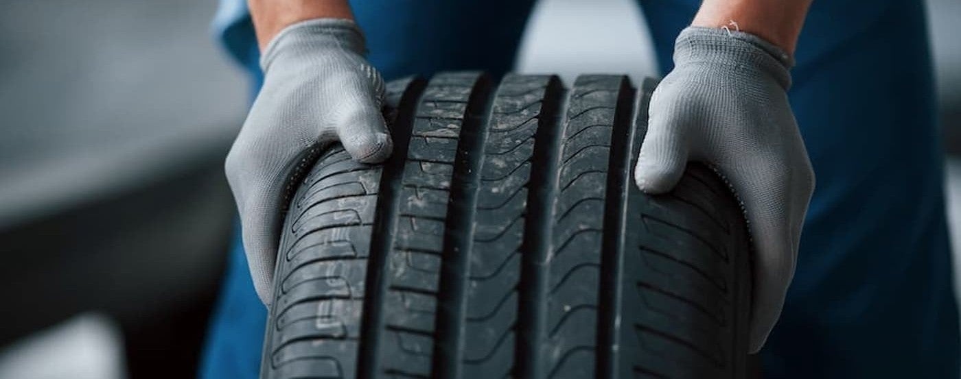 A technician pushing a tire.