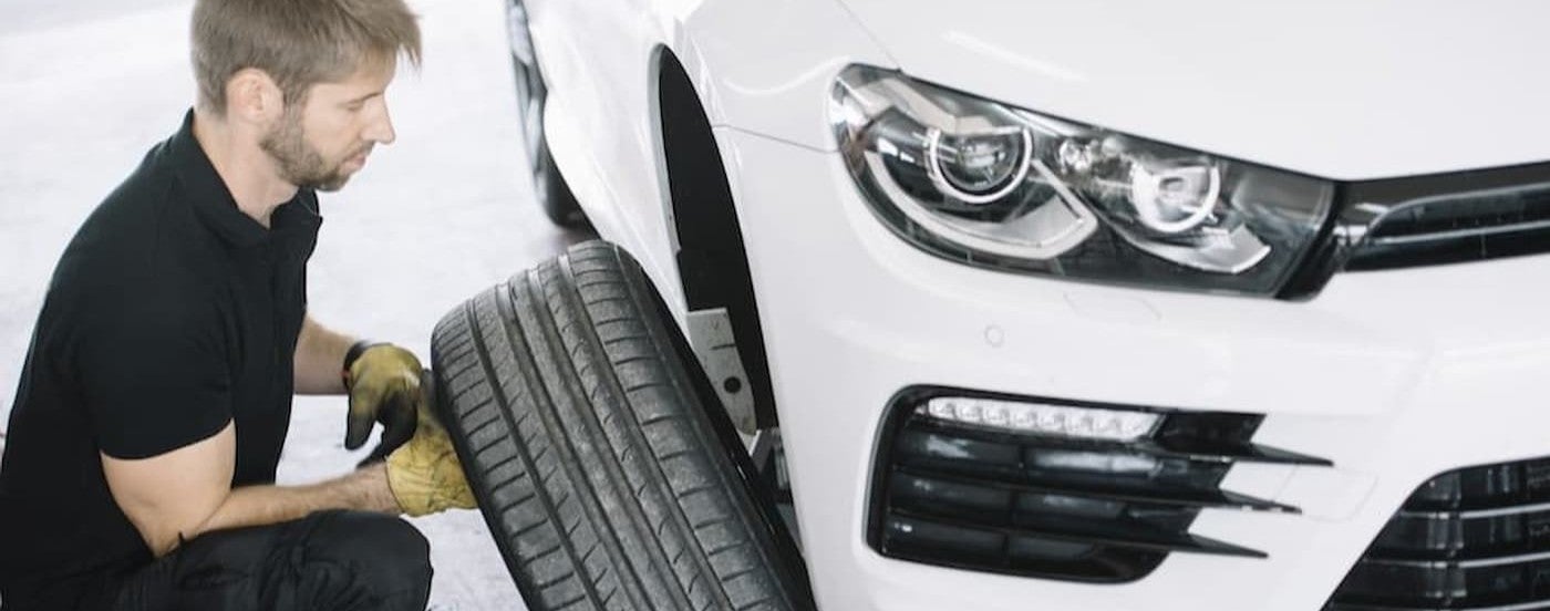 A technician taking a tire off of a vehicle.