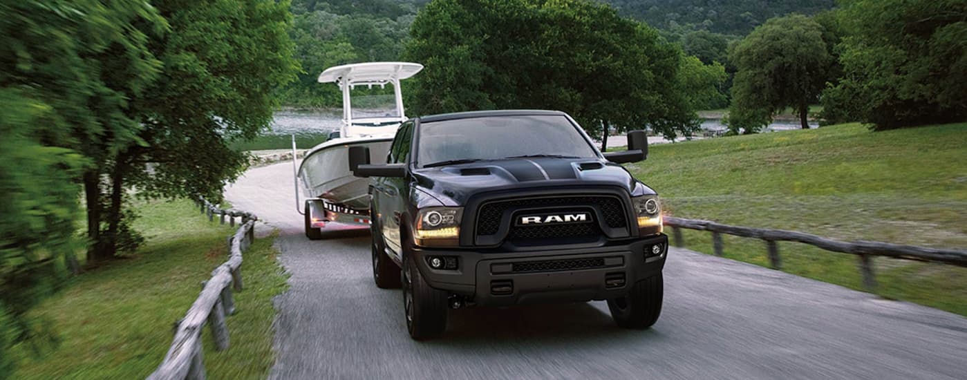Silver 2019 Ram 1500 towing a boat.