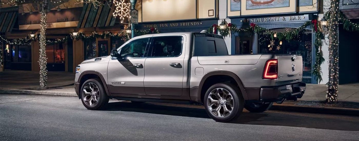 Rear of a silver 2020 Ram 1500 parked by a curb.